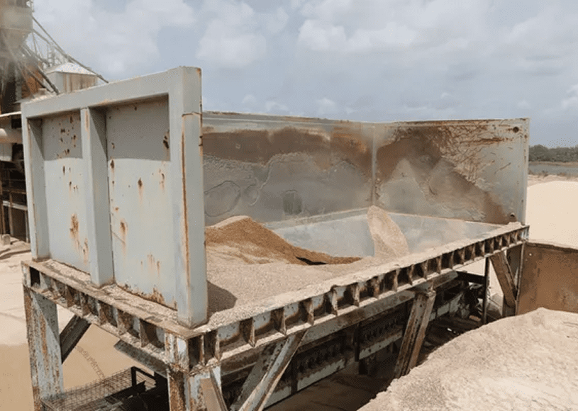 Rusty metal container filled with sand.