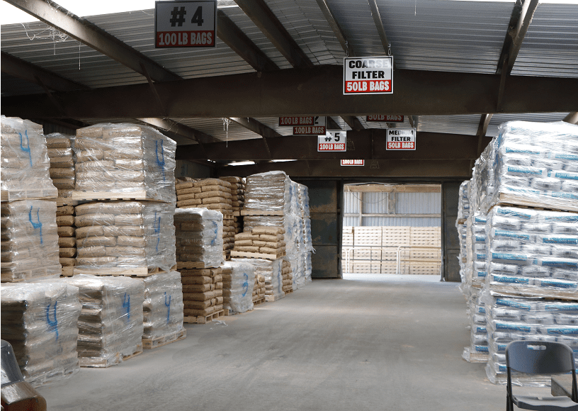 Warehouse with stacked bags and signs overhead.