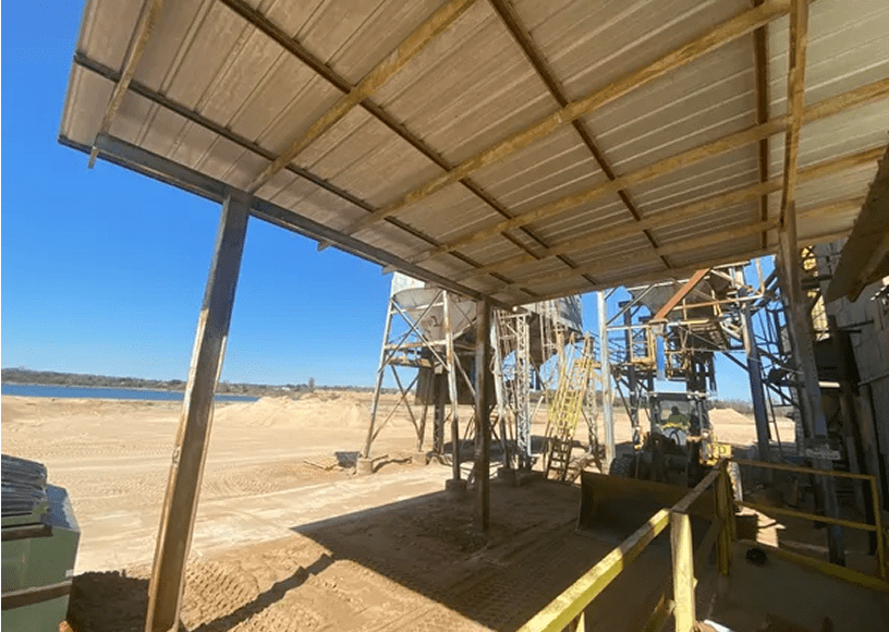 Industrial sand processing facility under clear sky.
